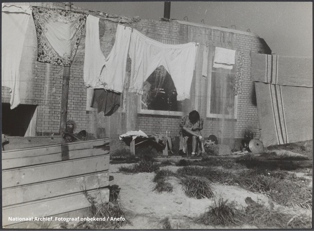 De was hangt te drogen voor een bunker waarin tijdelijk werd gewoond - Nationaal Archief. Fotograaf onbekend / Anefo